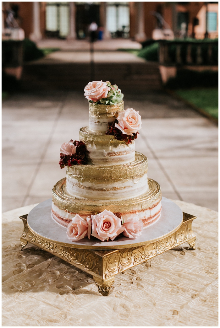 The wedding cake with floral and gold accents 